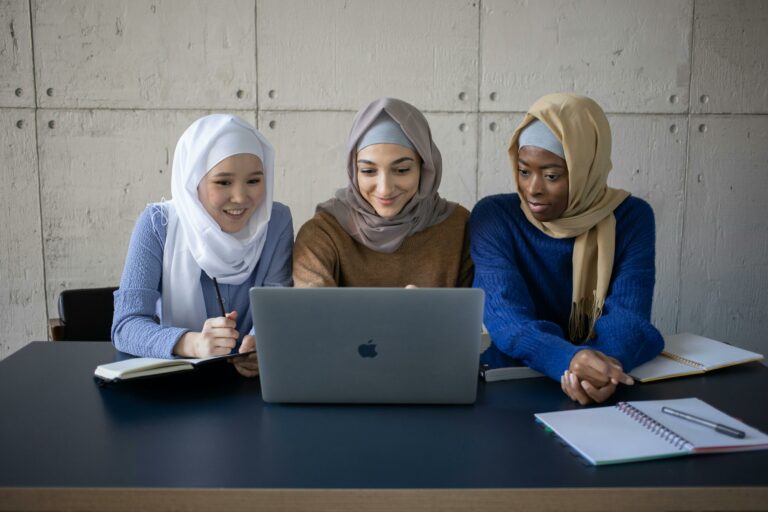Stock photo of three muslim women working with a laptop by gabby k
